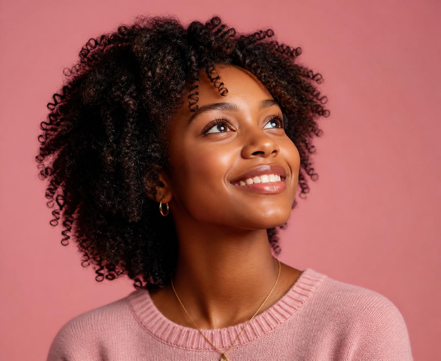 Young woman looking up with hope and confidence, wearing pink